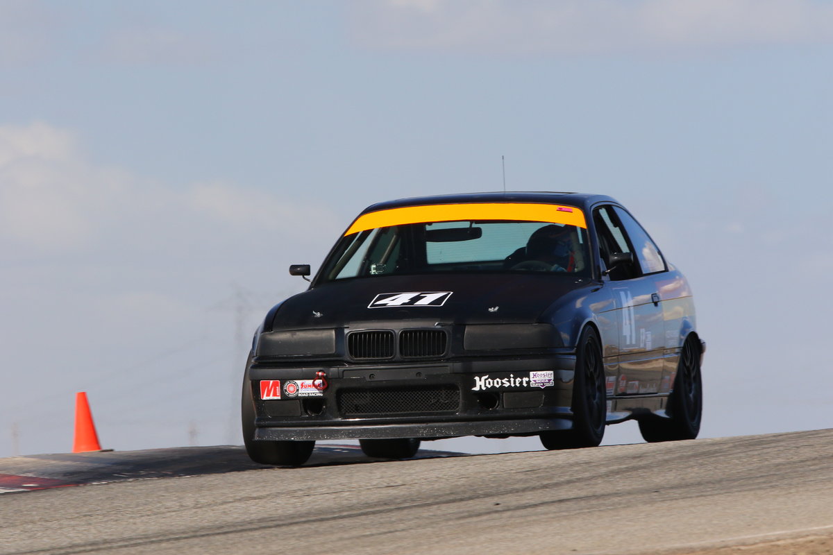 Mike Anderson's number 42 E36 BMW cresting a rise on track