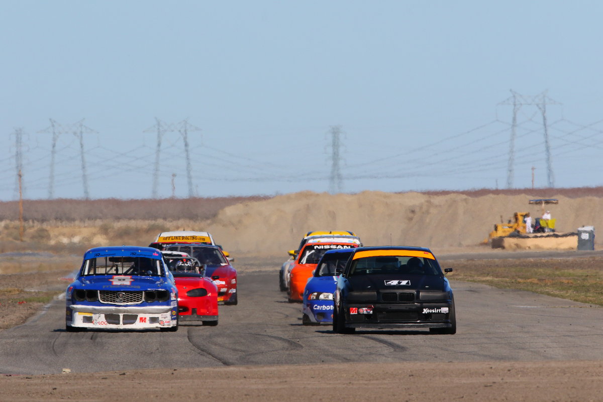 Mike Anderson's black number 42 E36 BMW leading an SCCA Production field