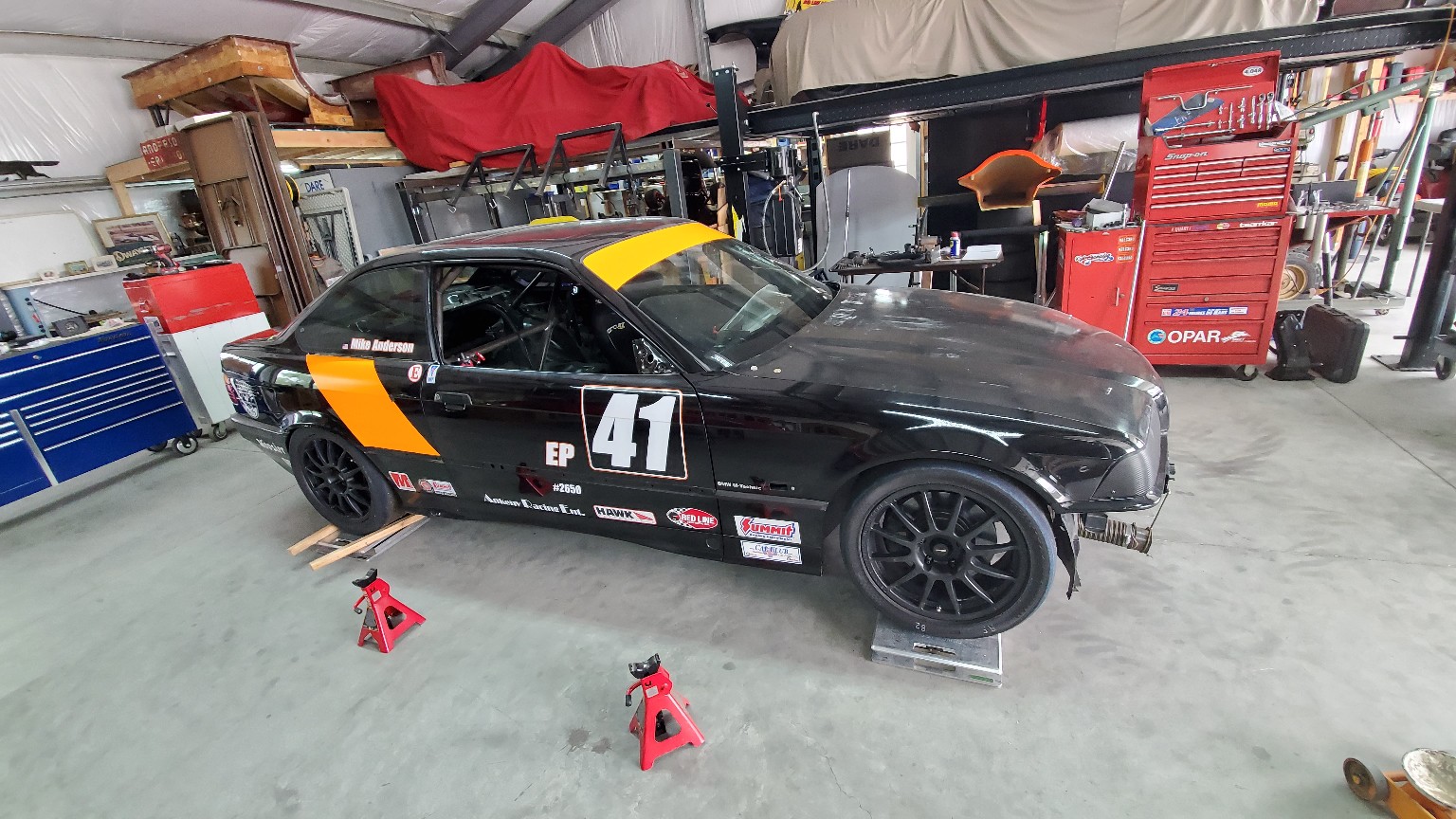 Mike Anderson's number 42 E36 BMW on stands in the race shop