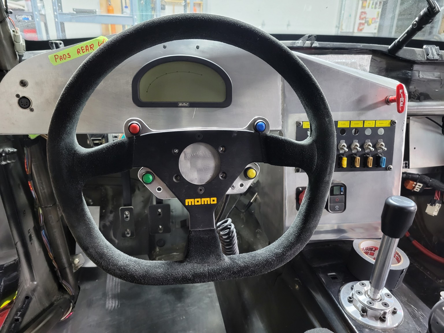 Momo steering wheel, digital display, shifter, and switch panel in the E36 BMW cockpit