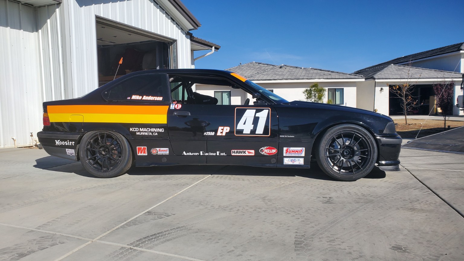 Finished black and orange E36 BMW race car number 41 in side profile