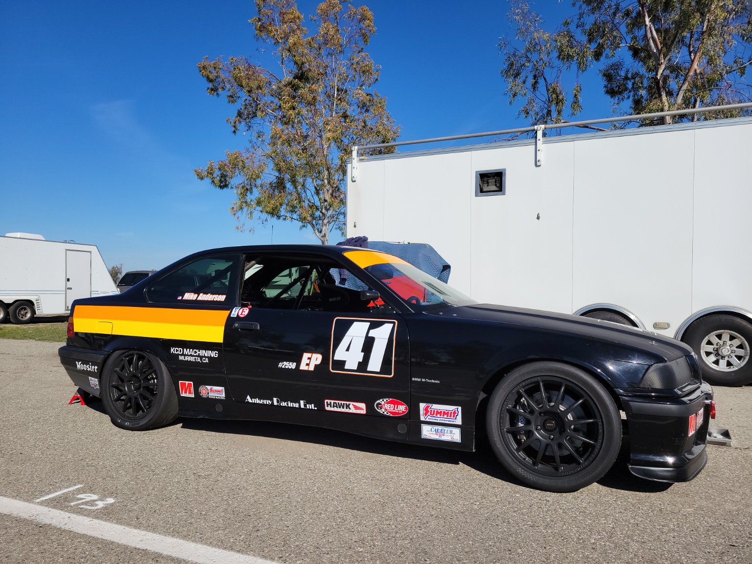Side profile of the black and orange E36 BMW number 41 in race trim