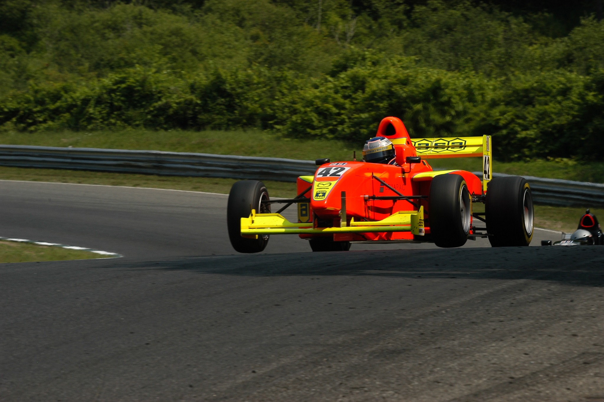 Mike Anderson's orange number 42 Pro Formula Mazda airborne over the crest at Lime Rock Park