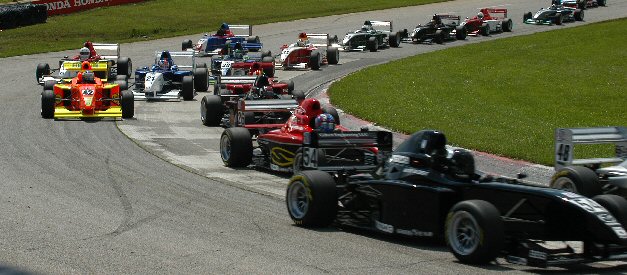 A large Pro Formula Mazda field racing through Mid-Ohio with Mike Anderson's orange number 42 in the pack