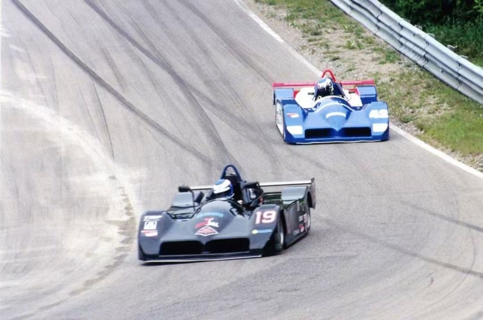 Mike Anderson's blue number 42 Sports Toyota chasing the number 19 car on track