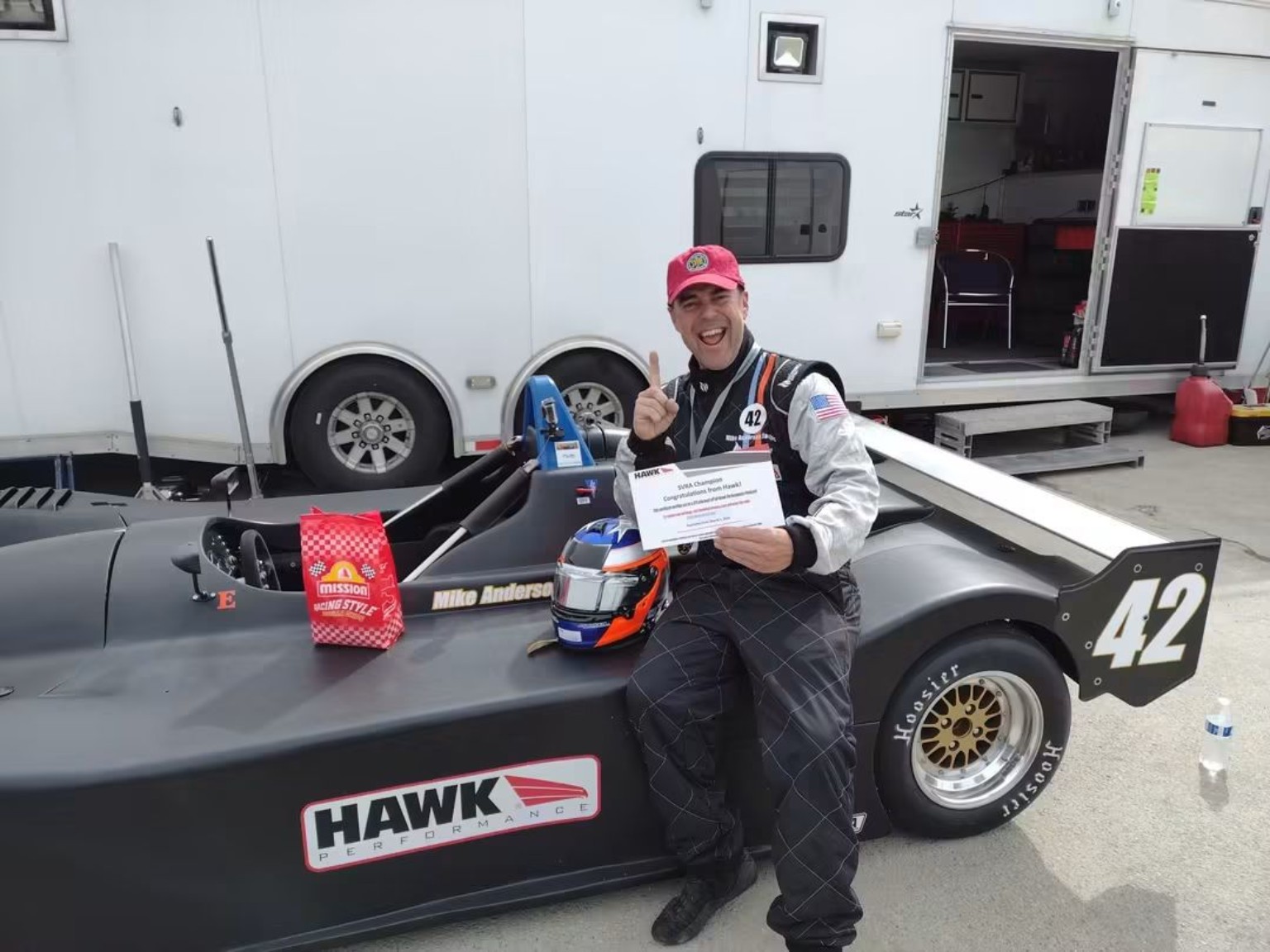 Mike Anderson celebrating beside his restored black number 42 Sports Toyota