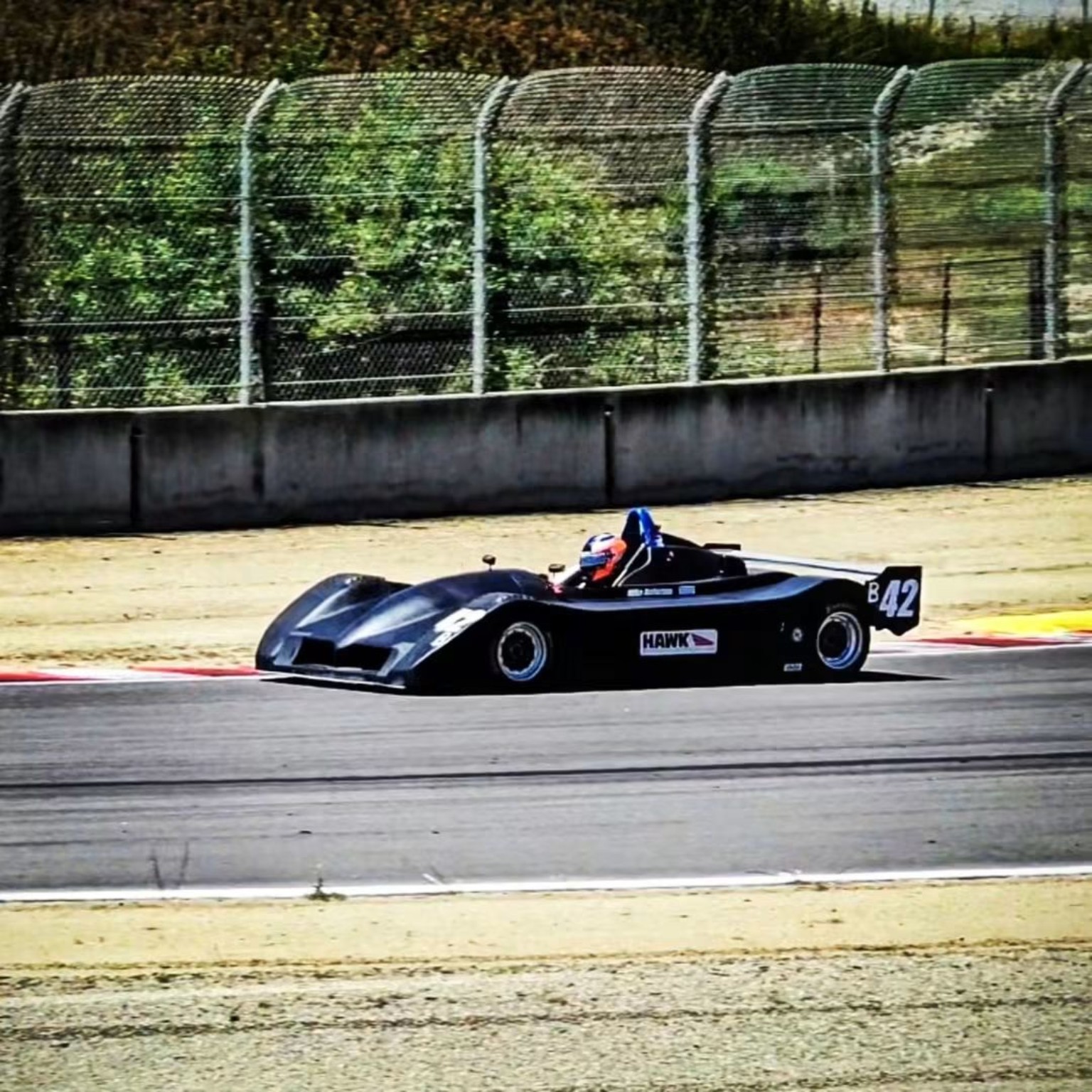 Mike Anderson driving his restored black number 42 Sports Toyota in vintage competition